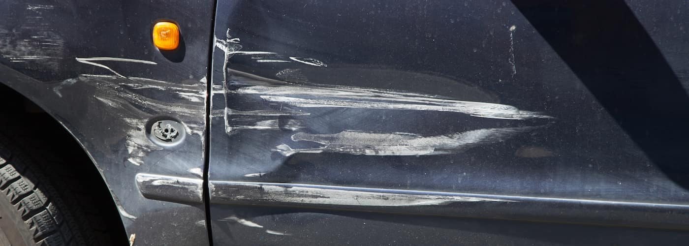 Deep scratches along the side of a dark car