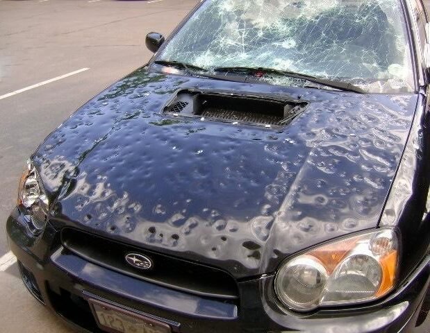 A car hood covered in hail dents