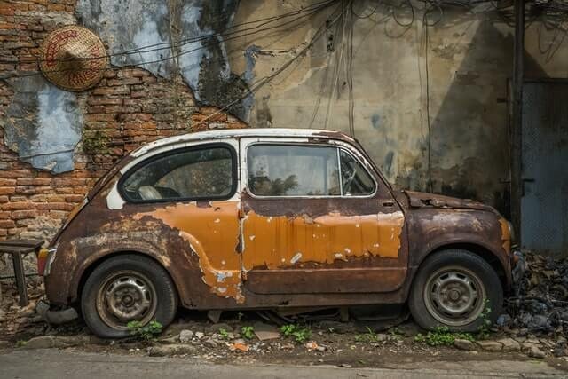 A rusted vintage car awaiting restoration