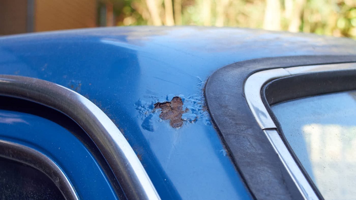 Rust bubbling through paint on a car roof